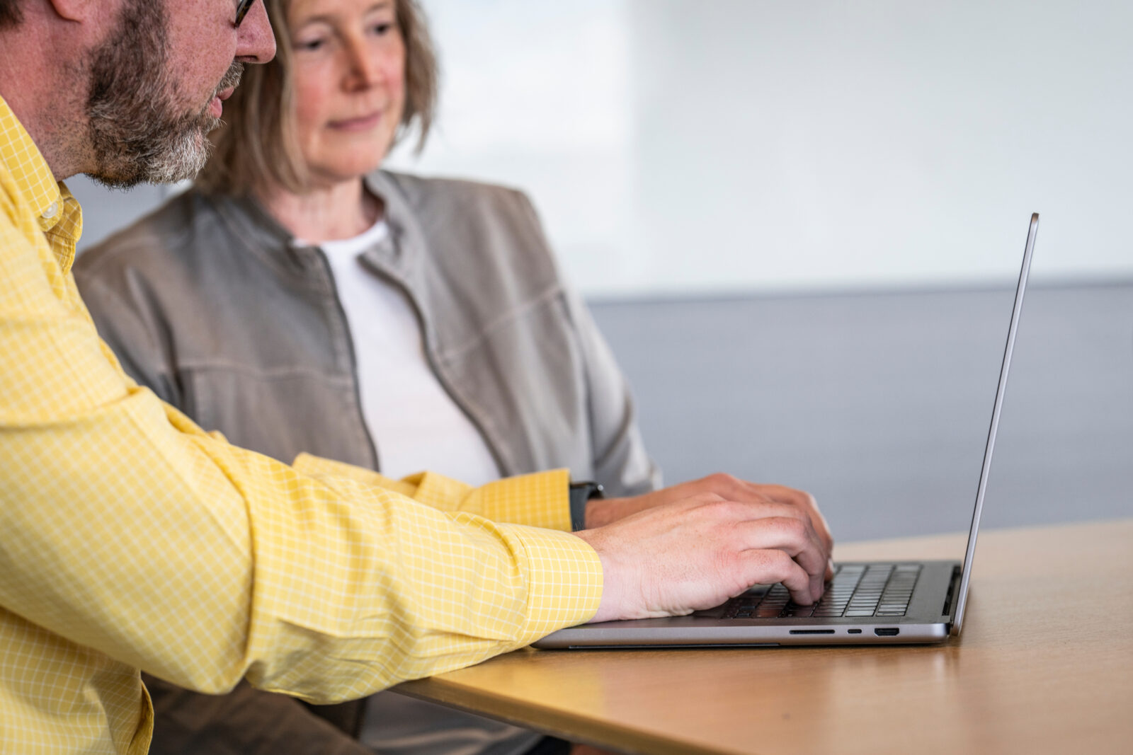 Two people studying together using a laptop