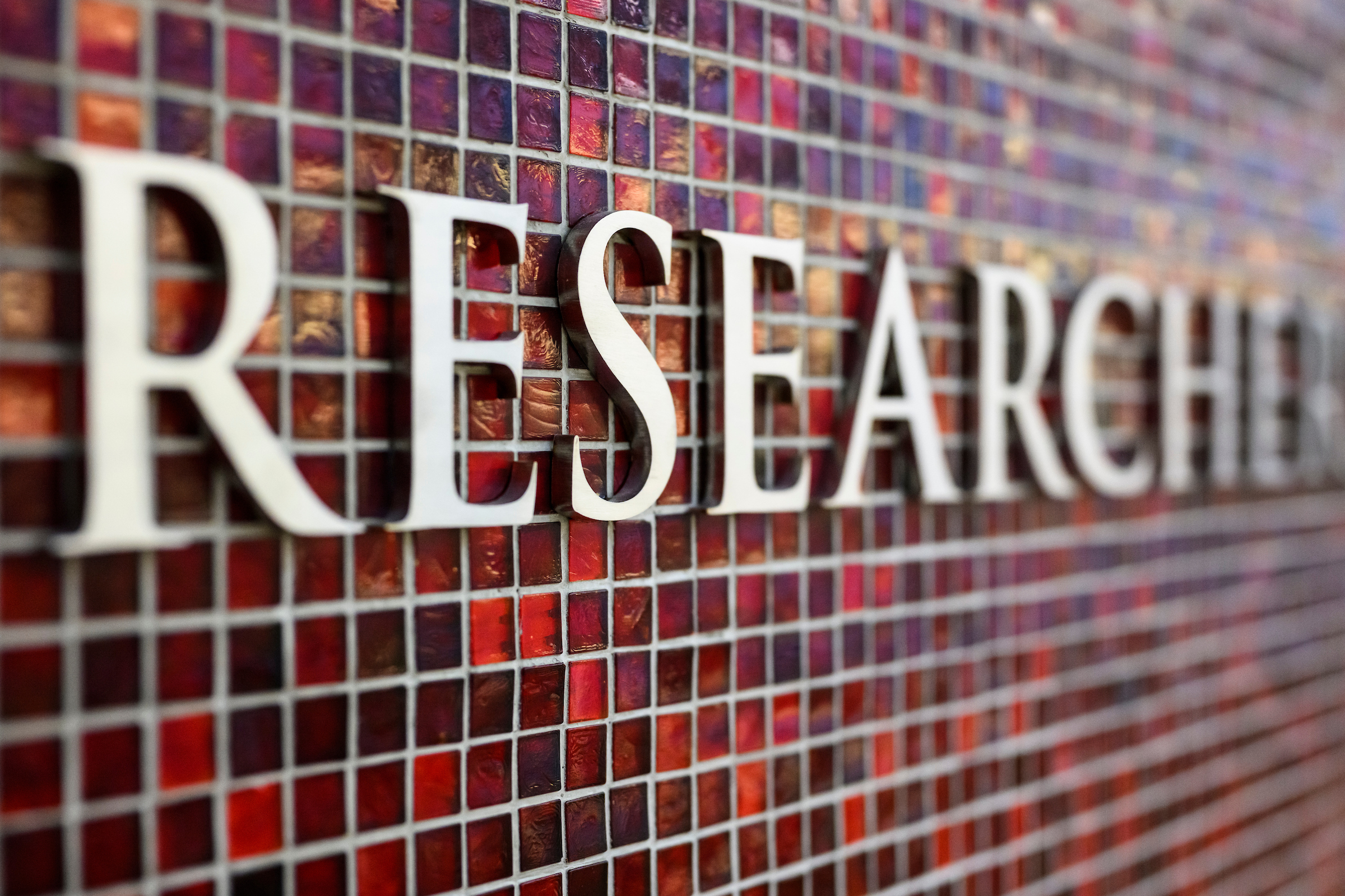 The word “research” on a red tile mosaic wall in the Discovery Building at UW–Madison